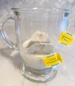 4 cozy chamomile teabags steeping in clear mug of milk