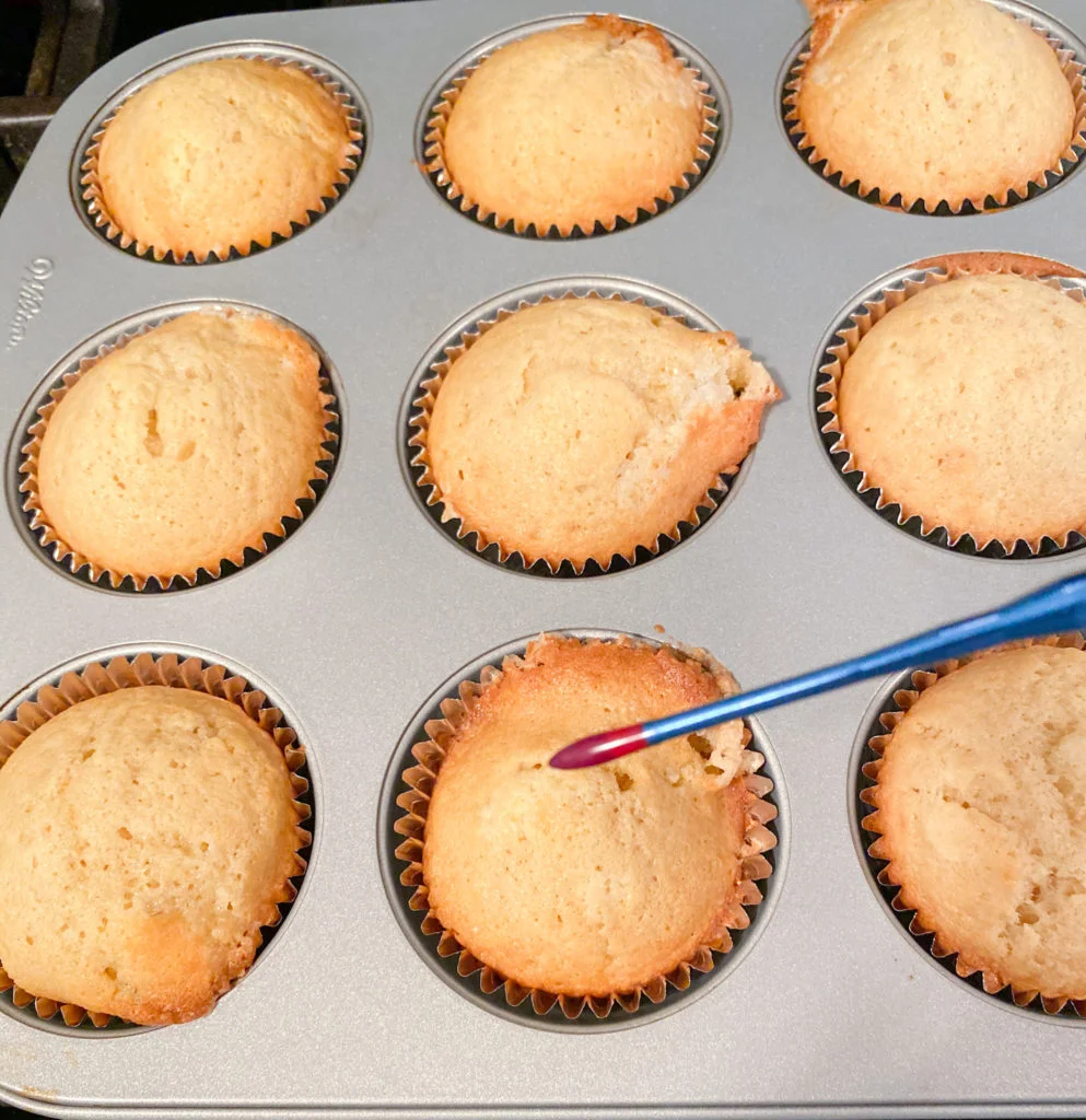 Bundt Baking Thermometer with bright red tip in front of tray of baked cupcakes in pan