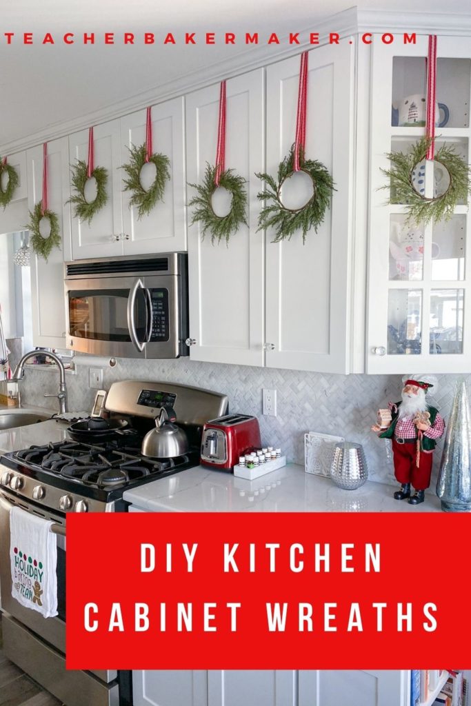 Pinterest image of White Shaker Kitchen cabinets with green wreaths hung with red and white ribbons with red text overlay box of DIY Kitchen Cabinet Wreaths