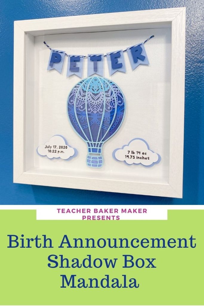 Pinterest Image of Birth Announcement Shadow Box Mandala of hot air balloon in shades of blue with vital stats on clouds and name spelled out on pennant banner, hung on blue wall, angled photo
