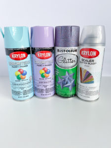 cans of Krylon spray paint in aqua, lavender, and glitter blast sealer, Rust-Oleum glitter purple spray paint can
