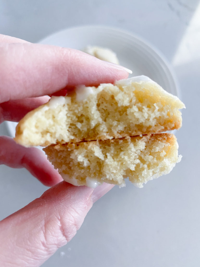 Closeup of lemon lime cookie cut in half and stacked with soft interior shown,held between fingers