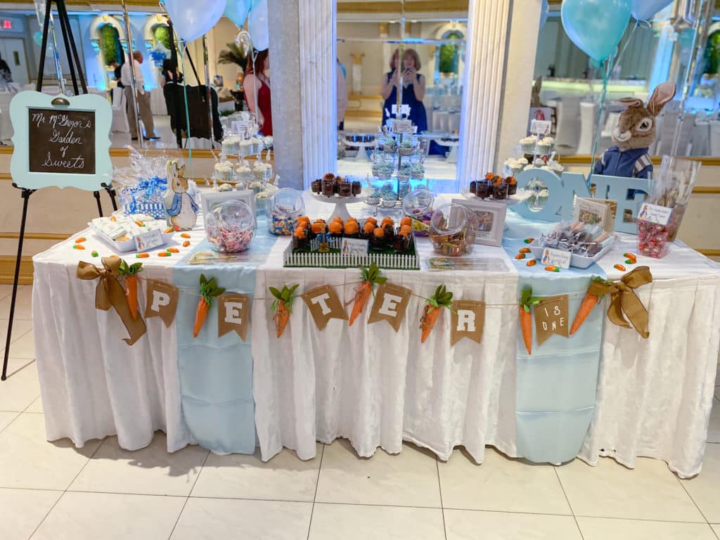 Peter Rabbit-themed sweets table with cupcake stands, candy, and chocolate covered strawberries