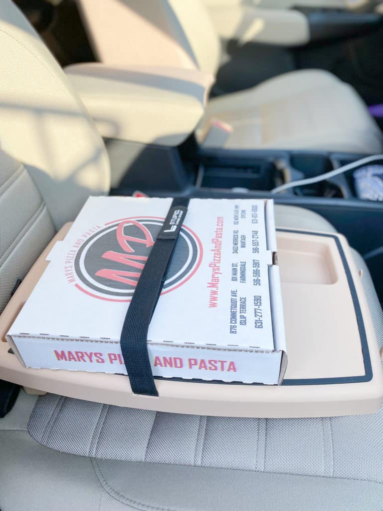 Small pizza box on Desert Stupid Car Tray on ivory passenger seat