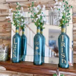 3 green bottles with Luck of the Irish in gold, gold twine around neck, and green/white berry sprays with white flowers