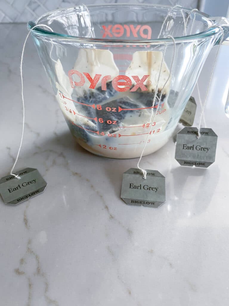 Glass measuring cup with milk and Earl Grey tea bags