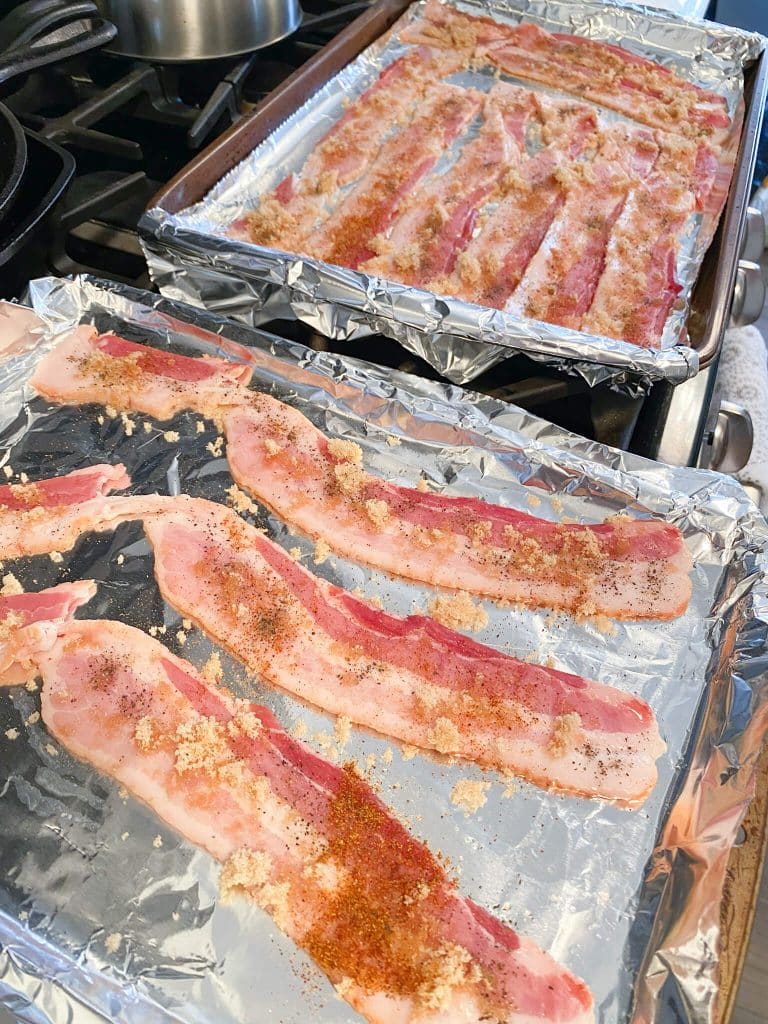 bacon strips on foil lined baking sheets, sprinkled with brown sugar and cayenne pepper