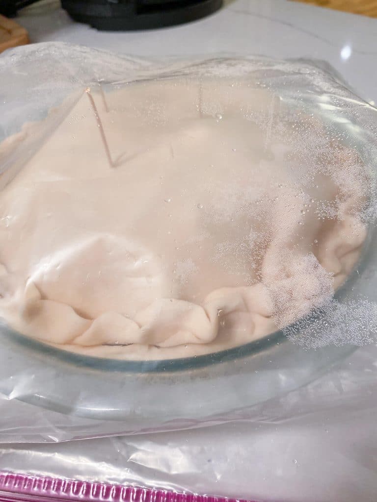 frozen apple pie in clear plastic bag with 3 toothpicks inserted in top crust to prop up bag