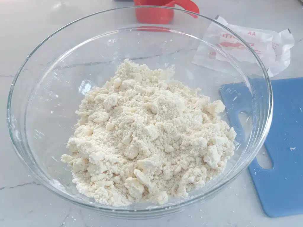 glass bowl with pie crust dough with butter worked into pea-sized pieces