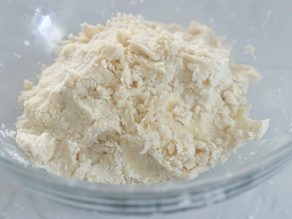 pie crust dough in a loose mound in a glass bowl