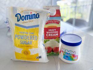 bag of powdered sugar, heavy cream, and jar of Jet puffed marshmallow fluff