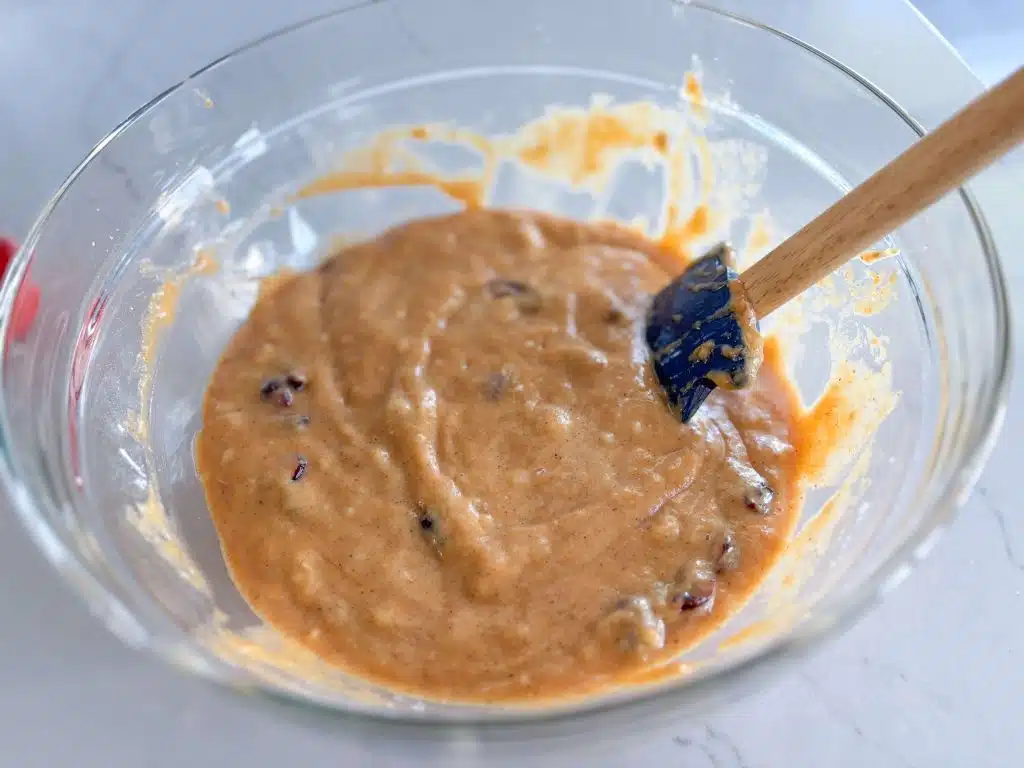 bowl of cranberry pumpkin batter with silicone spatula